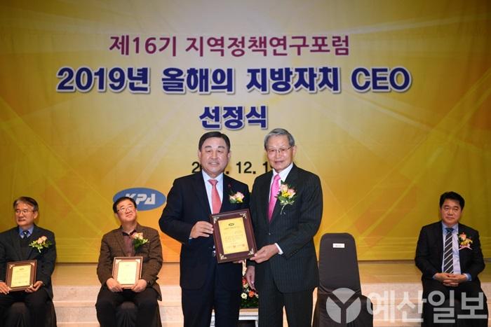 황선봉 군수(왼쪽)가 박우서 공공자치연구원 이사장으로부터 올해의 지방자치 CEO 패를 수상하는 모습.JPG